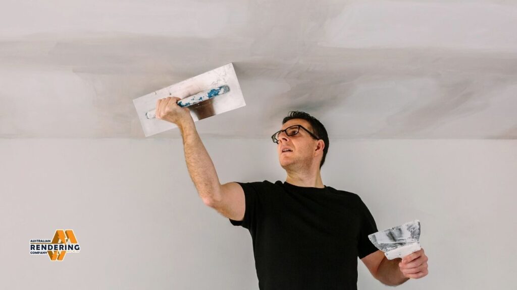 Man plastering ceiling with trowel