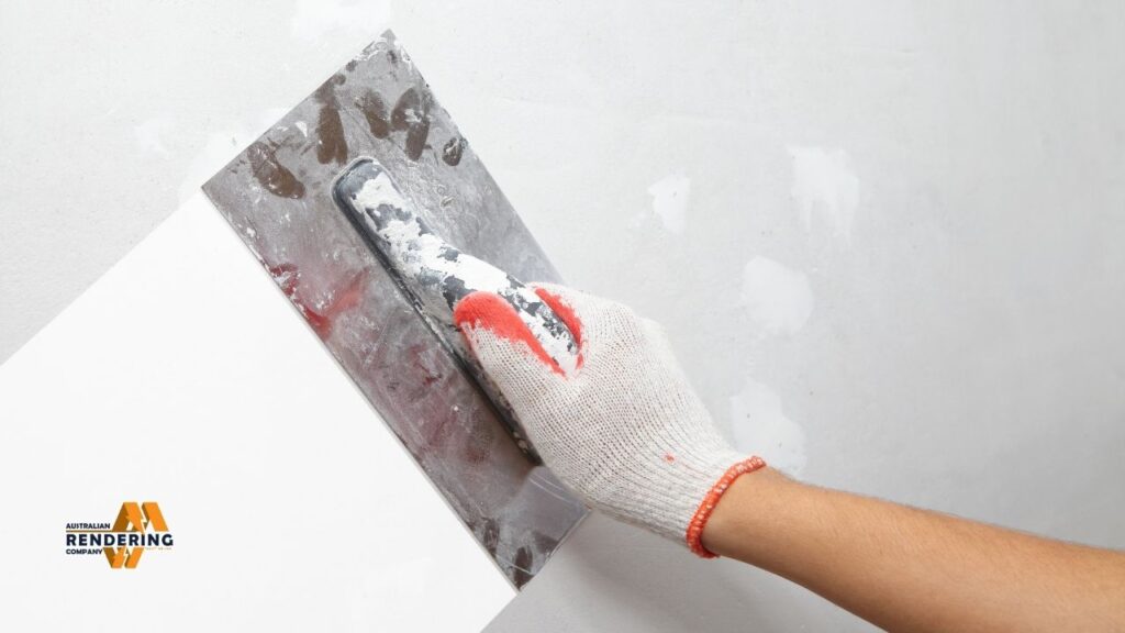 Plasterer smoothing wall with trowel