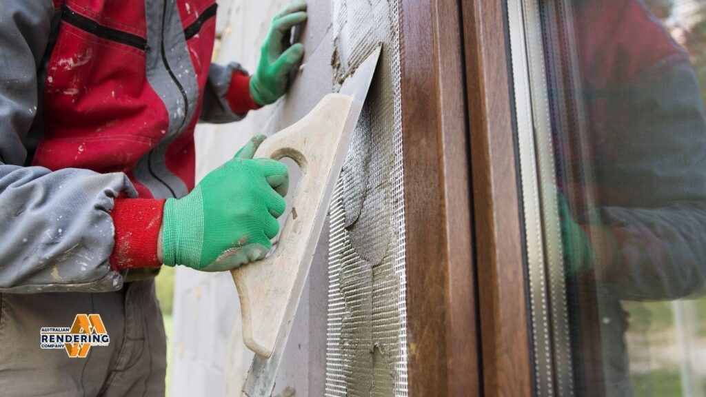 Worker applying render with trowel