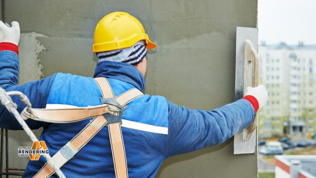Worker plastering wall with yellow hardhat
