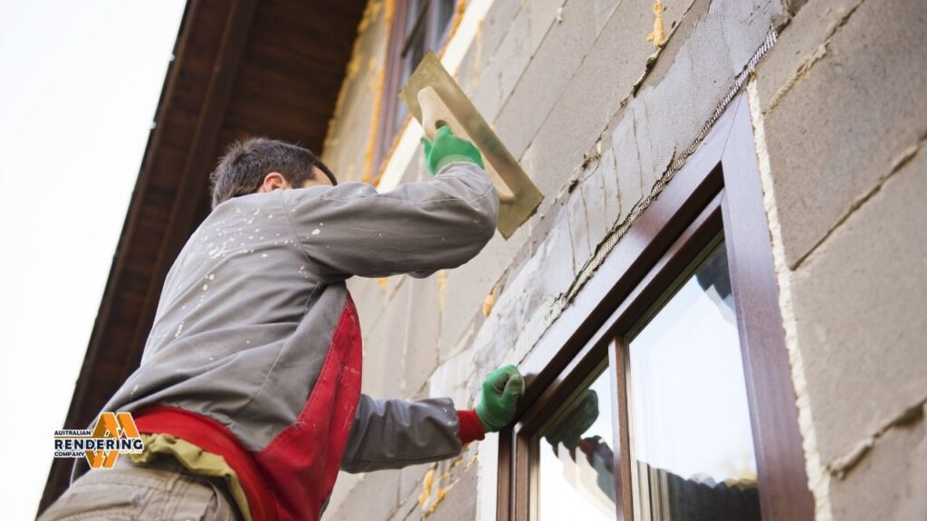 Worker rendering exterior wall with window