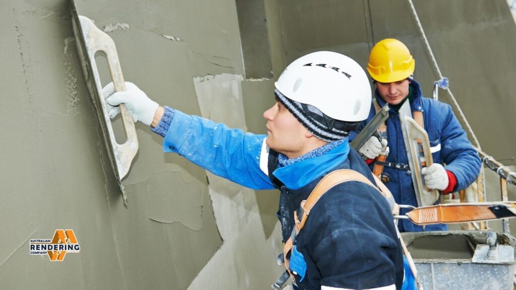 Workers applying stucco with trowel